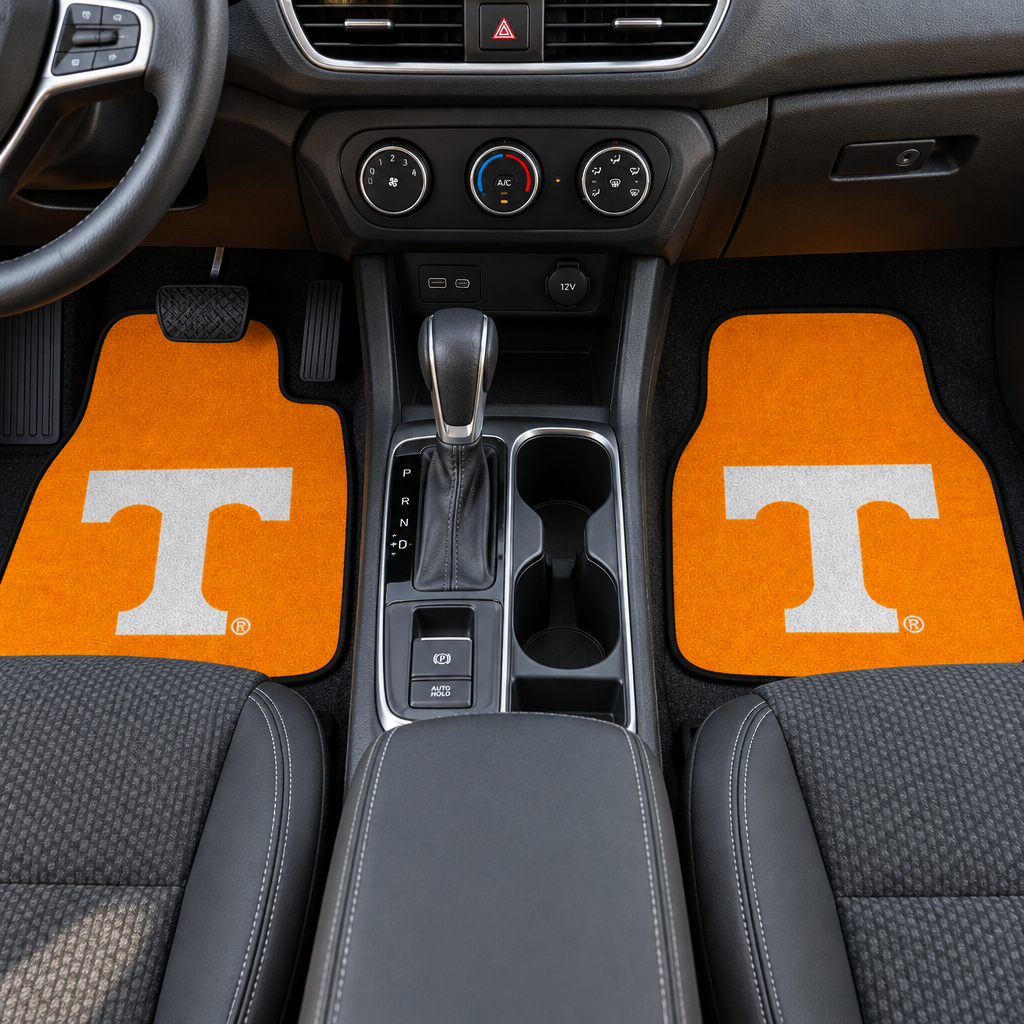 Two orange car floor mats with a white 'T' logo on a white background